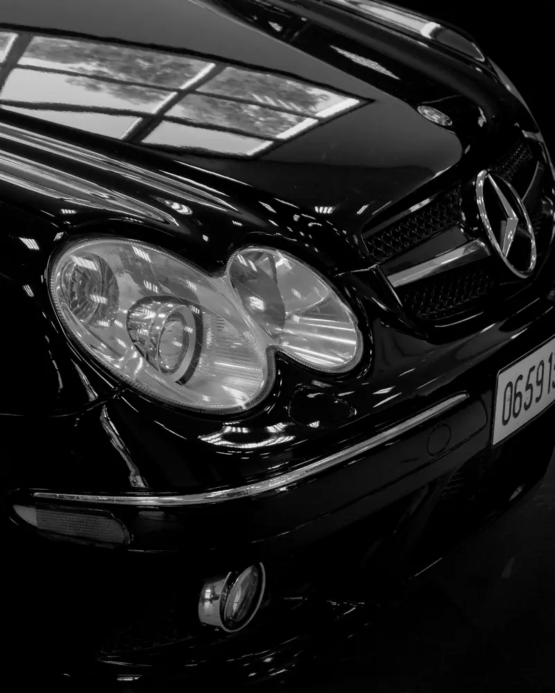 Dettaglio dei fari accesi di una Mercedes nera